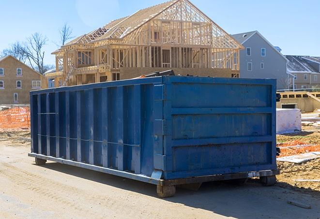 a large, green, residential dumpster sitting on a driveway